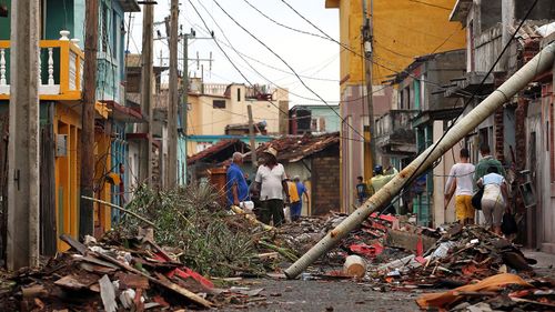 Cubans pick up the pieces following the damage and havoc caused by Hurricane Matthew in Baracoa. (AAP)