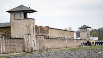 People walk the grounds of the former concentration camp at the Sachsenhausen Memorial, April 2023.