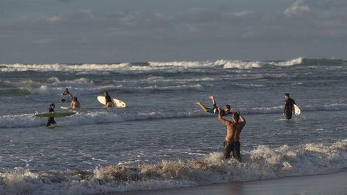 Swimmers and surfers are pictured at Wategos Beach in Byron Bay.