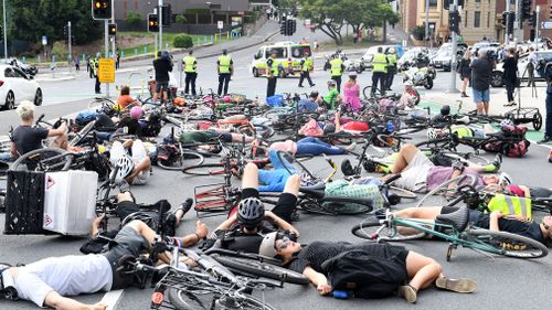 Cyclists block traffic during a 'Die-In' protest, obstructing peak-hour traffic at the Stanley and Vulture Street intersection. (AAP)