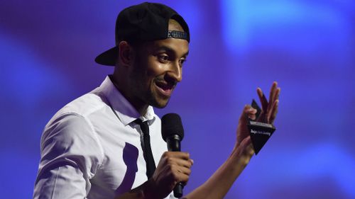 Triple J host Matt Okine accepts his award for best comedy release at the ARIAs. (AAP)