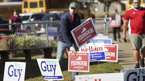 Last minute signs of support are placed for gubernatorial candidate Glenn Youngkin at the Bayside Sixth Grade Campus. 