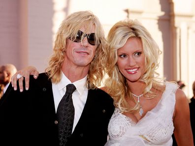 Musician Duff McKagan and designer Susan Holmes pose on the red carpet at the 32nd Annual "American Music Awards" at the Shrine Auditorium November 14, 2004 in Los Angeles, California. 