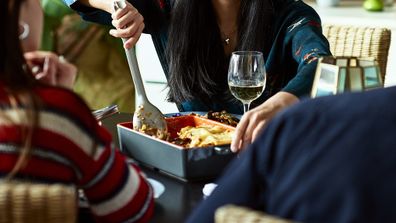 Family sharing lasagne meal