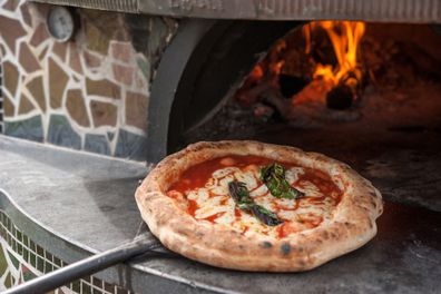 Hot pizza Margherita on the peel just out of the wood-fired oven.