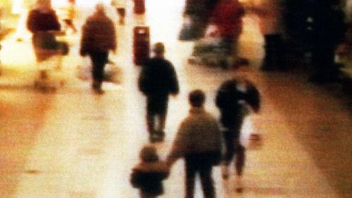 A still from CCTV shows two-years old James Bulger holding the hand of an unknown man as leaving a shopping center in Bootle, on February 16, 1993. (AAP)