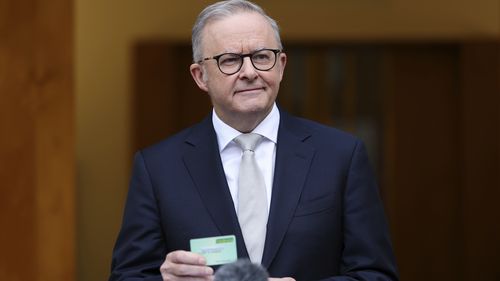 Prime Minister Anthony Albanese holds a medicare card during a press conference after visiting Government House to call for an election, at Parliament House in Canberra on Friday 28 March 202