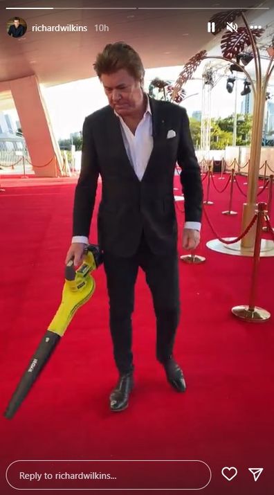 Richard Wilkins vacuums the red carpet at the 2022 Logies.