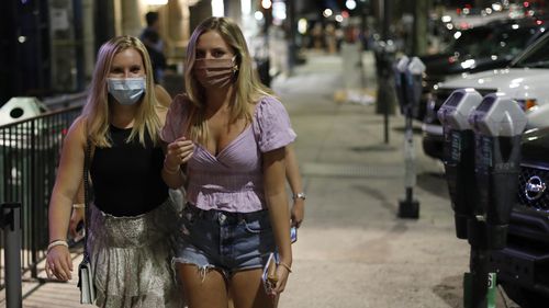 Women in masks walk along College Avenue in downtown Athens, Georgia, USA last month after The Athens-Clarke Commission approved a mandate on wearing masks when in public places and inside commercial establishments.