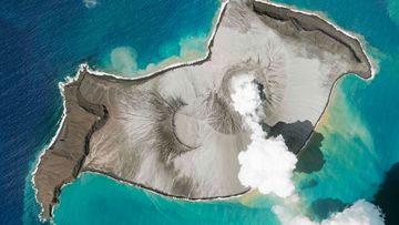 In this satellite photo taken by Planet Labs PBC, an island created by the underwater Hunga Tonga Hunga Ha&#x27;apai volcano is seen smoking on January 7. An undersea volcano erupted near Tonga yesterday, sending large tsunami waves crashing across the shore and people rushing to higher ground.