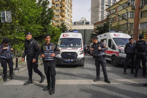 Police officers cordon off an area as firefighters and medical teams work after a fire broke out in a nightclub in Istanbul, Turkey, Tuesday, April 2, 2024 