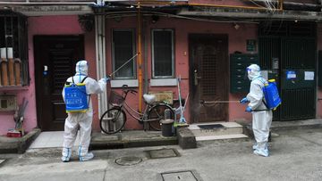 SHANGHAI, CHINA - APRIL 24: Volunteers wearing personal protective equipment (PPE) disinfect a residential community at Yangpu district during the phased lockdown triggered by the COVID-19 outbreak on April 24, 2022 in Shanghai, China. (Photo by Yang Jianzheng/VCG via Getty Images)