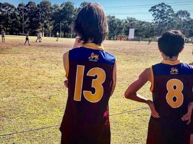 LJ's son at an AFL match on sidelines