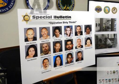 A poster showing photos of suspects, some of whom remain at large, is seen at a news conference to announce indictments against the Mexican Mafia in Los Angeles Wednesday, May 23, 2018. (AP Photo/Brian Melley)
