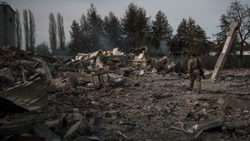 A volunteer of the Ukrainian Territorial Defence Forces walks on the debris of a car wash destroyed by a Russian bombing in Baryshivka, east of Kyiv, Ukraine, Friday, March 11, 2022