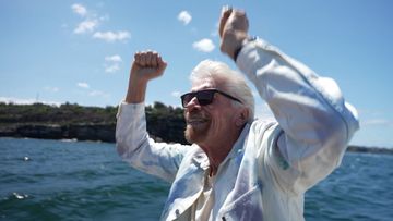 Billionaire tycoon Sir Richard Branson took to a speedboat as he welcomed one of his cruise ships into Sydney Harbour for the first time.