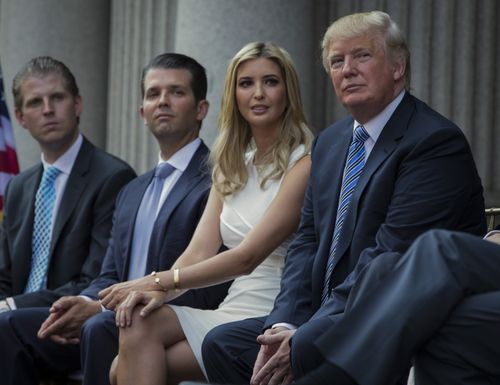 Donald Trump, right, sits with his children, from left, Eric Trump, Donald Trump Jr., and Ivanka Trump during a groundbreaking ceremony for the Trump International Hotel on July 23, 2014, in Washington. 