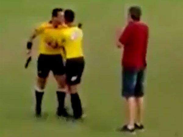A referee threatens players and officials with a handgun. (Supplied)