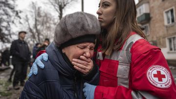 A woman cries in front of the building which was destroyed by a Russian attack in Kryvyi Rih, Ukraine, Friday.