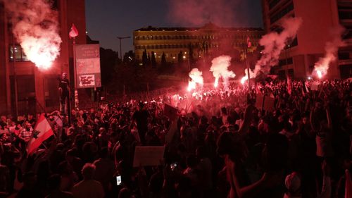 Anti-government protesters light flares and shout slogans against the Lebanese government during a protest in Beirut, Lebanon, Monday, Oct. 21, 2019. 