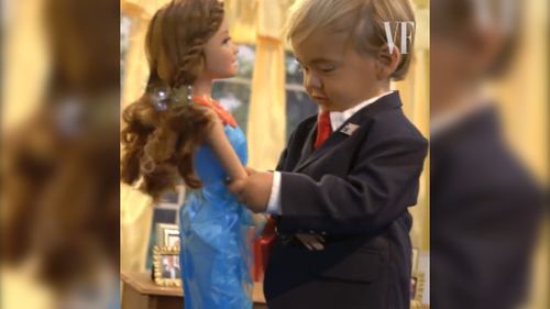 Mini Trump plays with building blocks and a doll during the Vanity Fair Video.