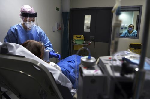 A Sydney nurse in St Vincent's Hospital emergency department's red zone inside an isolation room tends to a patient suspected of having coronavirus COVID-19