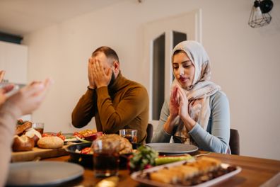 Traditional Muslim family sharing pita bread during dinner on Ramadan