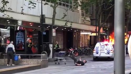 He falls to the ground before getting back up - following them - and ramming his trolley again.