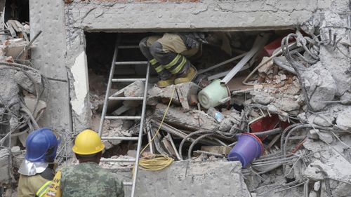 Fire crews sift through the rubble. (AP)