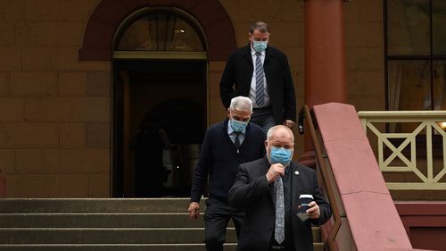 A group of men wearing face masks leave NSW Parliament House after NSW Agriculture Minister Adam Marshall tested positive for COVID-19. 