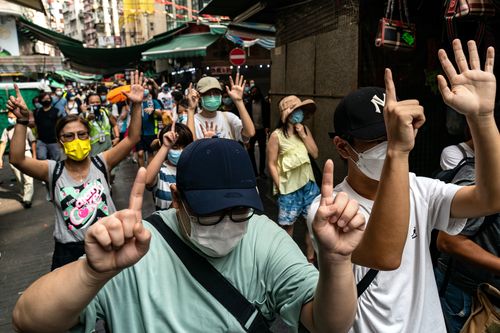 Protesters make gestures and shout slogans as they march on the street during an anti-government protest