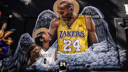 Adam Dergazarian, bottom center, pays his respects for Kobe Bryant and his daughter, Gianna, in front of a mural painted by artist Louie Sloe Palsino in Los Angeles. (AP Photo/Jae C. Hong, File)