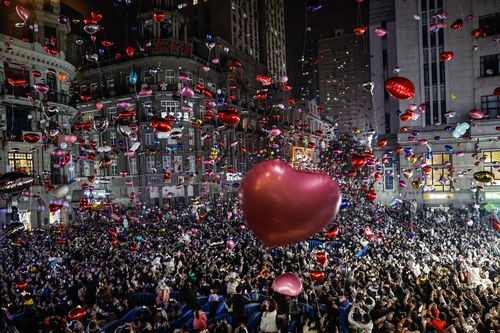 Des fêtards lâchent des ballons pour célébrer le Nouvel An dans la rue piétonne Jianghan Road le 31 décembre 2022 à Wuhan, en Chine.
