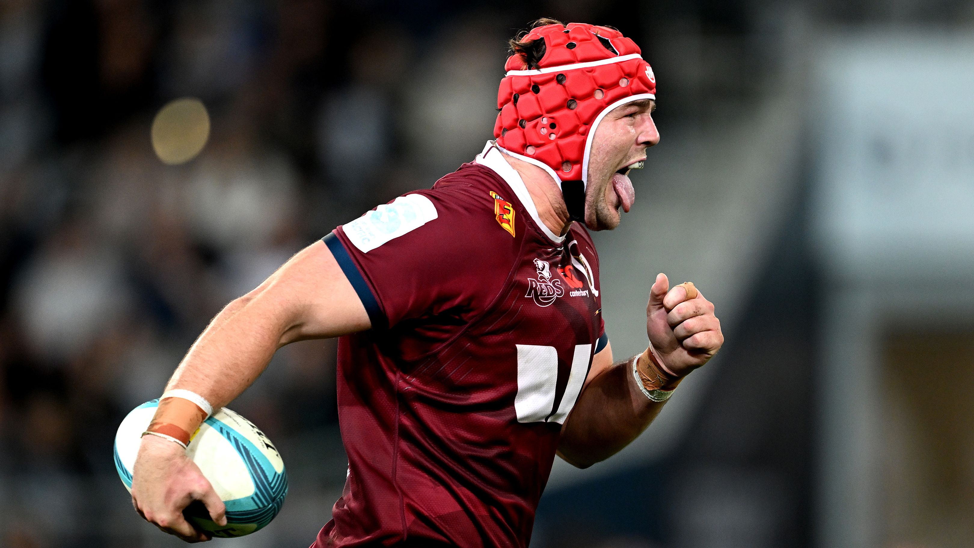 Queensland Reds bolter Harry Wilson sticks his tongue out as he sprints towards the Highlanders defence.