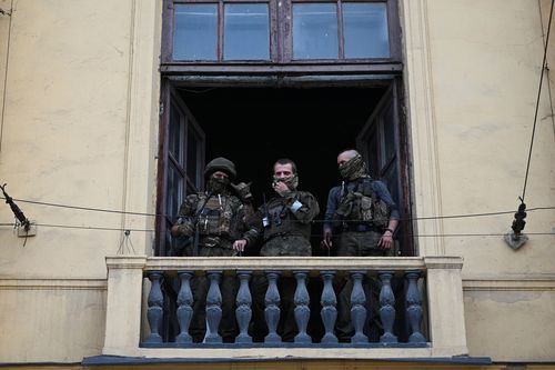 Fighters of Wagner private mercenary group stand on a balcony while being deployed at the headquarters of the Southern Military District in the city of Rostov-on-Don, Russia, June 24, 2023. 
