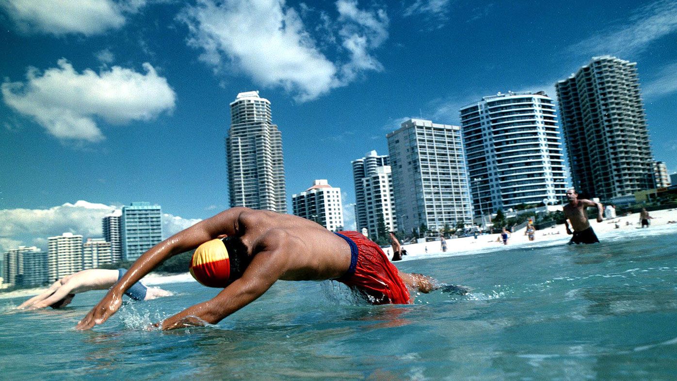 A life guard dives into the water on a Gold Coast beach.