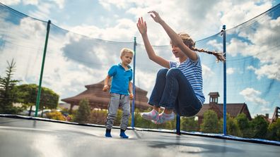 Boy and girl jumping on trampoline