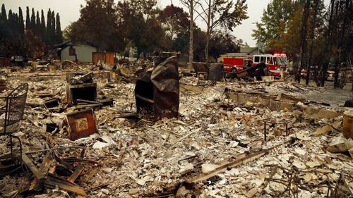 Firefighters drive through the Coffey Park area of Santa Rosa looking for hotspots. (AP)