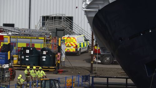 Emergency teams attend the scene after a ship tipped over at a 45-degree angle in the Imperial Dock area in Leith on March 22, 2023 in Leith, Scotland.