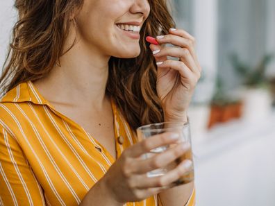 Young adult woman taking supplements.