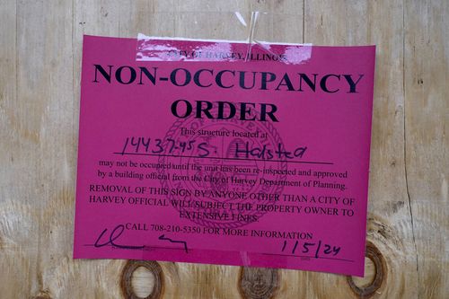 A no-occupancy order is taped on plywood at an apartment 