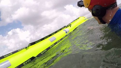 The drone drops a small package which inflates to a bright floating tube when it hits water.