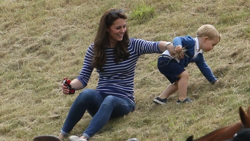 The young prince playfully rolled around next to his smiling and laughing mother. (AAP)
