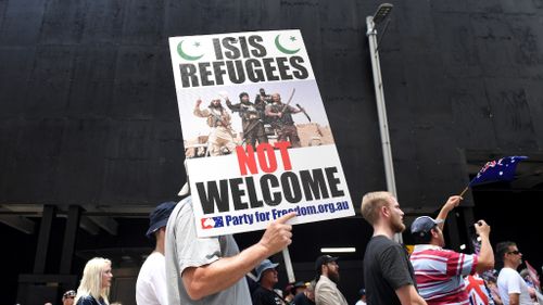 Many participants are carrying signs and Australian flags. (AAP)