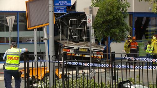 A truck has crossed a busy road and smashed into the side of a building in Sydney's west.