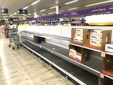 Bare toilet paper and tissue shelves in Sydney supermarket.