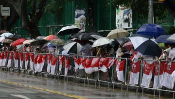  People line up in the streets in the rain waiting for the start of the State Funeral Procession for the late Lee Kuan Yew before it leaves Parliament House. (Getty Images)