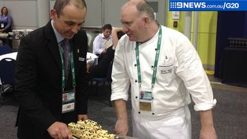Brisbane convention centre's executive chef Martin Latter and food and drink manager Lawrence Bolton try some of the dishes. (9NEWS)