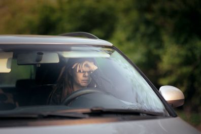 sad Woman driving feeling anxiety behind the wheel car