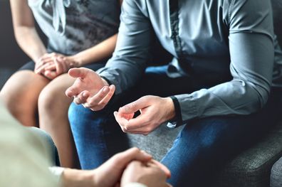 Couple counseling or therapy session. Man talking about problems in the family. Husband and wife meeting their psychiatrist. Discussion with marriage counselor, mediator or relationship psychologist.